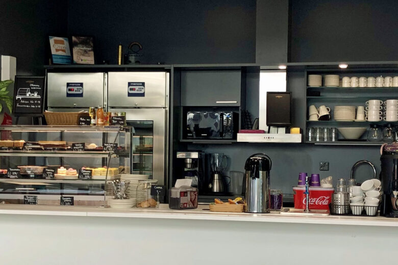 Aidan herkut -kahvilan myyntitiski, jossa esillä leivonnaisia, kahvipannut ja astioita.