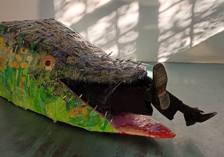 Ihminen roskista tehdyn kalan sisällä